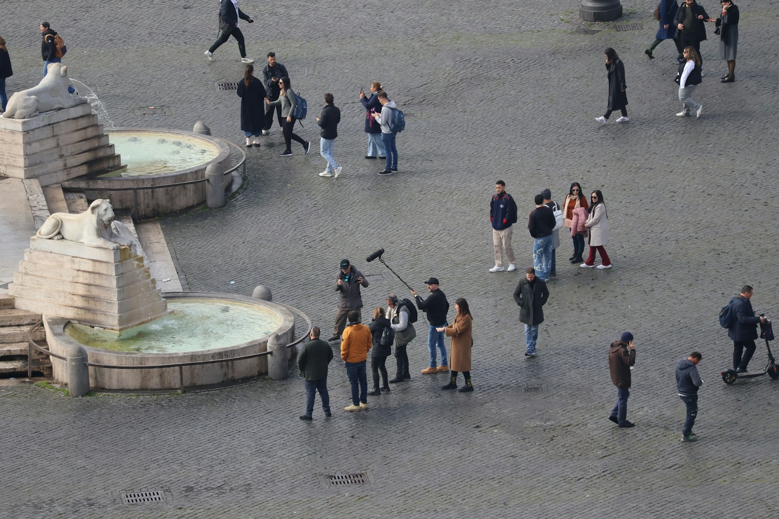 a group of people standing around a fountain